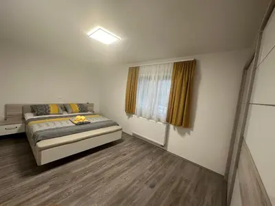 a small bedroom with a bed and a window at Apartments Harmony Joe in Radenci