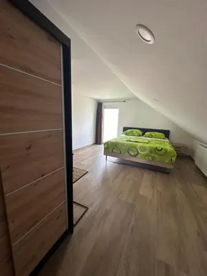 a bedroom with a bed with a green blanket at Apartments Harmony Joe in Radenci
