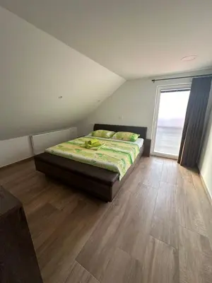 a bedroom with a bed and a large window at Apartments Harmony Joe in Radenci