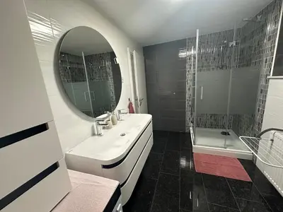 a bathroom with a sink and a mirror and a tub at Apartments Harmony Joe in Radenci
