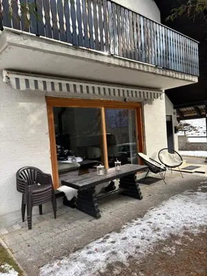 a patio with a table and a chair and a balcony at Chalet Gozd Martuljek in Gozd Martuljek