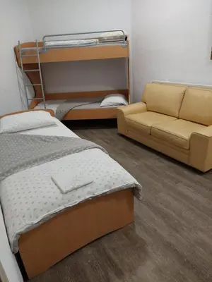 a room with a bed and a couch and a bunk bed at Hostel - Rooms Kaj & Kaja in Slivnica pri Mariboru