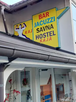 a sign for a restaurant on the side of a building at Hostel - Rooms Kaj & Kaja in Slivnica pri Mariboru