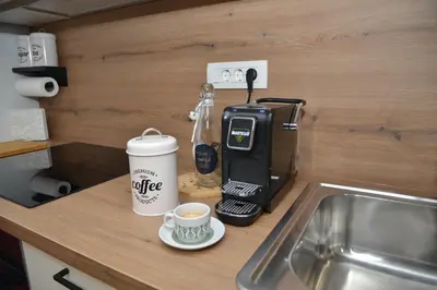 a coffee machine sitting on a counter next to a cup of coffee at Slosarjeva Holiday House - Alpine View & Modern Comfort in Preddvor