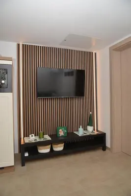 a living room with a television on a striped wall at Slosarjeva Holiday House - Alpine View & Modern Comfort in Preddvor