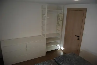 a room with a closet with white cabinets and a door at Slosarjeva Holiday House - Alpine View & Modern Comfort in Preddvor