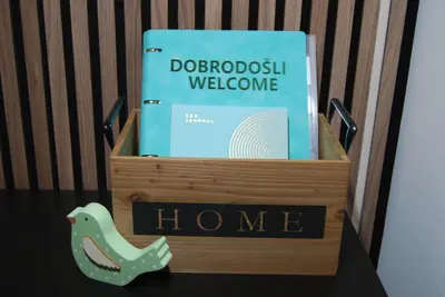 a wooden box with a book on top of a table at Slosarjeva Holiday House - Alpine View & Modern Comfort in Preddvor