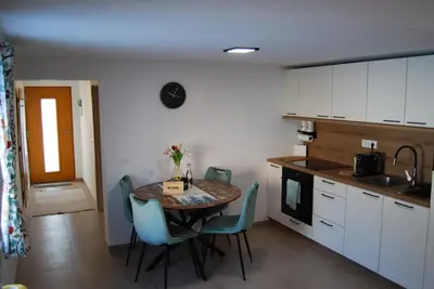 a kitchen with a table and chairs in a room at Slosarjeva Holiday House - Alpine View & Modern Comfort in Preddvor