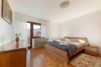 a bedroom with a bed and a large window at Apt Regina with balcony and parking in Bled