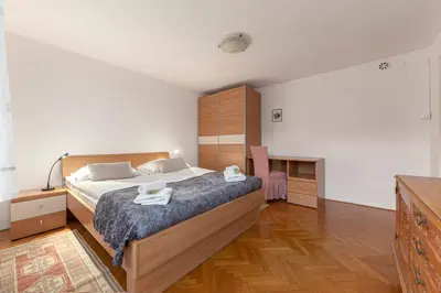a bedroom with a large bed and a desk at Apt Regina with balcony and parking in Bled