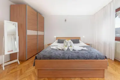a bedroom with a bed with two people laying on it at Apt Regina with balcony and parking in Bled