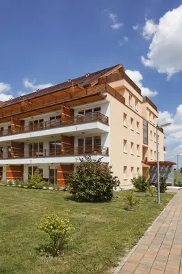 a large building with a grassy yard in front of it at Apartma Moravske Toplice in Moravske Toplice