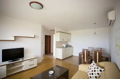 a living room with a couch and a tv and a table at Apartma Moravske Toplice in Moravske Toplice