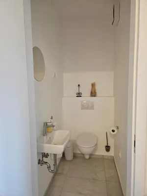 a white bathroom with a toilet and a sink at Sunny AP22 in Bovec