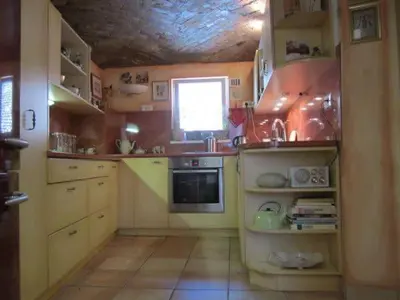 a small kitchen with yellow cabinets and a window at A precious apartment in Ljubljana in Ljubljana