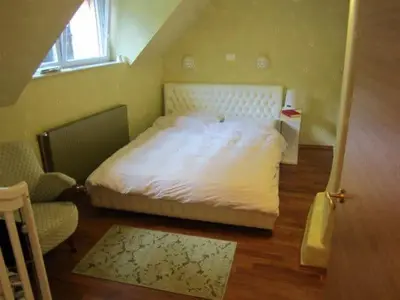a bedroom with a bed and a chair and a window at A precious apartment in Ljubljana in Ljubljana