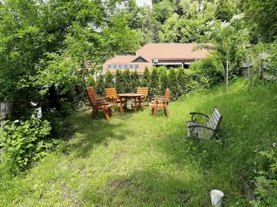 a garden with a table and chairs in the grass at A precious apartment in Ljubljana in Ljubljana