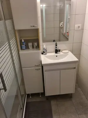 a white bathroom with a sink and a mirror at Ten villages in Žirovnica