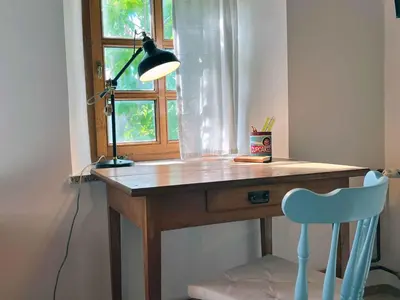 a desk with a lamp and a chair in front of a window at Holiday home in Semic - Kranjska (Krain) 51757 in Semič
