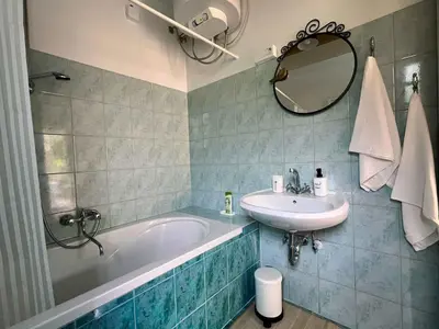 a bathroom with a tub and a sink and a mirror at Holiday home in Semic - Kranjska (Krain) 51757 in Semič
