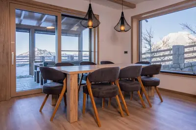 a dining room with a wooden table and chairs at Vila Klif vacation home with sauna and terrace in Cerklje na Gorenjskem