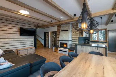 a living room with a wooden table and a fireplace at Vila Klif vacation home with sauna and terrace in Cerklje na Gorenjskem