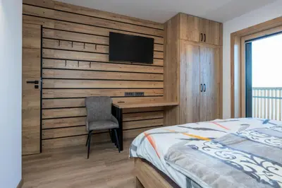 a bedroom with a bed and a desk with a television at Vila Klif vacation home with sauna and terrace in Cerklje na Gorenjskem