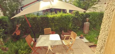 a patio with an umbrella and a table and chairs at Dom AteLJe in Ljubljana