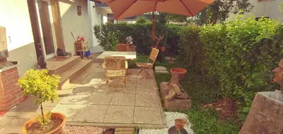 a patio with two chairs and an umbrella at Dom AteLJe in Ljubljana