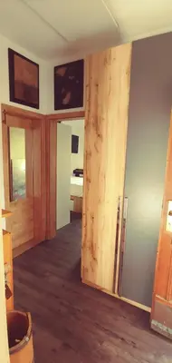 a room with a wooden door and a room with a bed at Dom AteLJe in Ljubljana