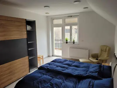 a bedroom with a blue bed and a window at Kranj Leisure Apartment in Kranj