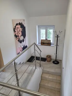 a hallway with stairs with a painting on the wall at Kranj Leisure Apartment in Kranj