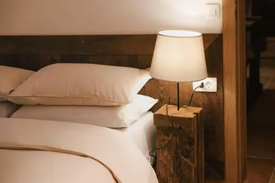 a bedroom with a bed with a lamp next to it at Guesthouse Novak -Modern Barn Loft in Dvor
