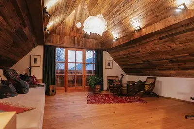 a living room with wooden ceilings and a large window at Guesthouse Novak -Modern Barn Loft in Dvor