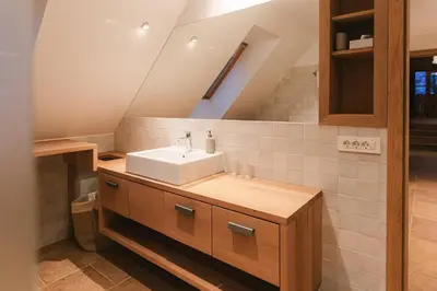 a bathroom with a white sink and a staircase at Guesthouse Novak -Modern Barn Loft in Dvor