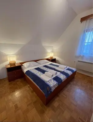 a bedroom with a bed with two lamps and a window at Terme Čatež apartma Maestro in Čatež ob Savi