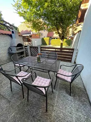 a patio with a table and chairs and a tree at Terme Čatež apartma Maestro in Čatež ob Savi