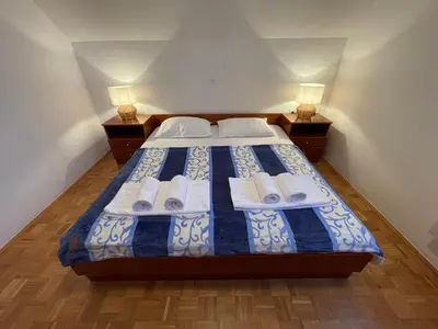 a bedroom with a bed with towels and two lamps at Terme Čatež apartma Maestro in Čatež ob Savi