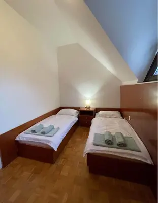 two beds in a small bedroom with a roof at Terme Čatež apartma Maestro in Čatež ob Savi