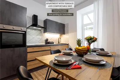 a kitchen with a wooden table with chairs and a dining room at Celje City Stay in Celje