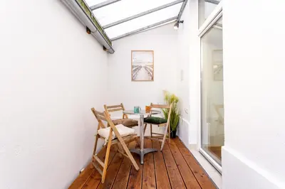 a room with a table and chairs on a wooden floor at Celje City Stay in Celje