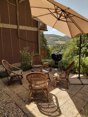 a patio with chairs and an umbrella and a grill at Holiday apartement Sentjur in Šentjur