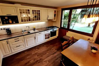 a kitchen with white cabinets and a table and a window at Cozy 3BR Alpine House in Gozd Martuljek