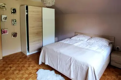 a bedroom with a white bed and a closet at Cozy 3BR Alpine House in Gozd Martuljek