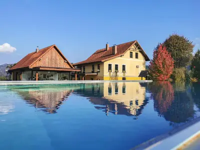 a house is reflected in a pool of water at Geratičevo in Lovrenc na Pohorju