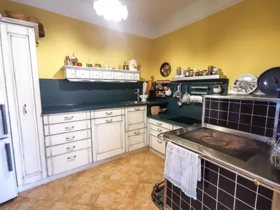 a kitchen with white cabinets and a black counter top at Geratičevo in Lovrenc na Pohorju