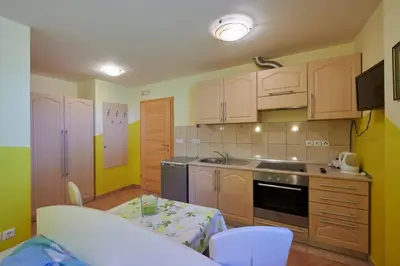 a kitchen with wooden cabinets and a table in it at Tourist farm Kolar in Ljubno