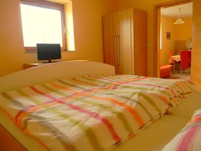a bedroom with a bed with a colorful blanket at Tourist farm Kolar in Ljubno
