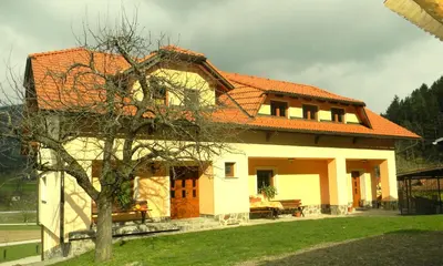 a house with an orange roof and a tree at Tourist farm Kolar in Ljubno