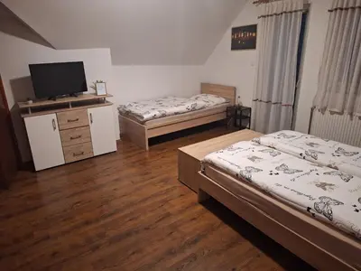 a room with two beds and a television in it at Apartma Studio Bogi in Kranjska Gora